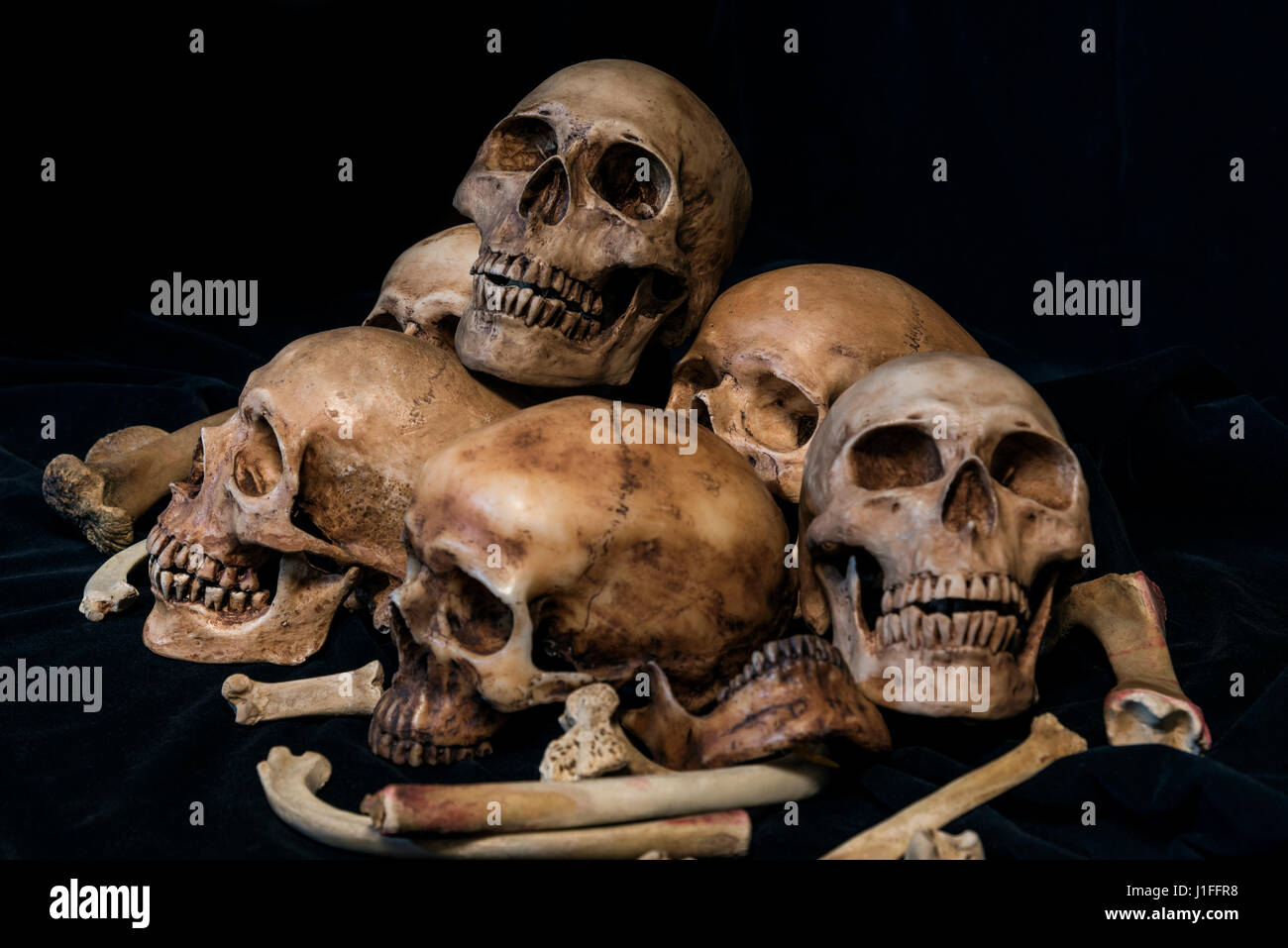 Pila di teschi e le ossa di animali sul tessuto nero lo sfondo. I genocidi concetto ancora lo stile di vita. Foto Stock
