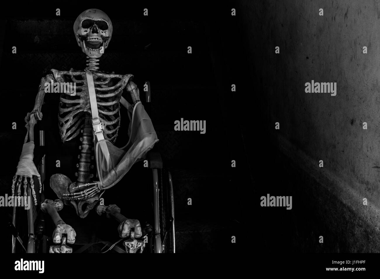 Abbandonato edificio ospedaliero ghost living place con scheletro umano seduto nella sedia a rotelle e tenebre horror e halloween concetto di sfondo Foto Stock