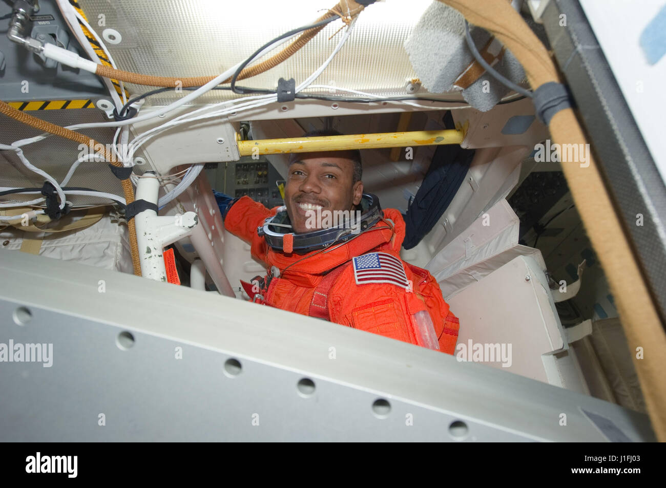 La NASA Stazione Spaziale Internazionale STS-133 missione il primo equipaggio astronauta Alvin Drew indossa il suo lancio arancione e voce tuta spaziale di atterraggio a bordo della navetta spaziale Discovery middeck prima dello sbarco il 9 marzo 2011 in orbita intorno alla terra. (Foto di Foto NASA /NASA via Planetpix) Foto Stock