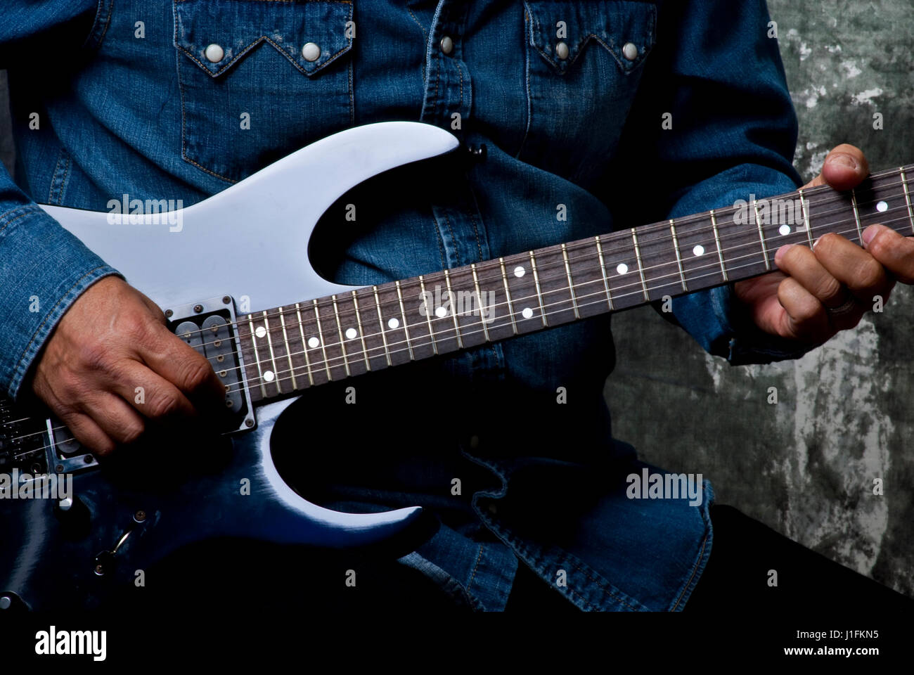 Uomo a suonare la chitarra solo corpo non faccia vedere il collo e il corpo della chitarra Foto Stock