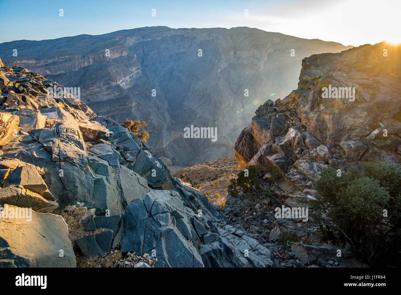 Jebel Shams; sole risplende nel corso del vertice e gorge in Oman il Grand Canyon Foto Stock