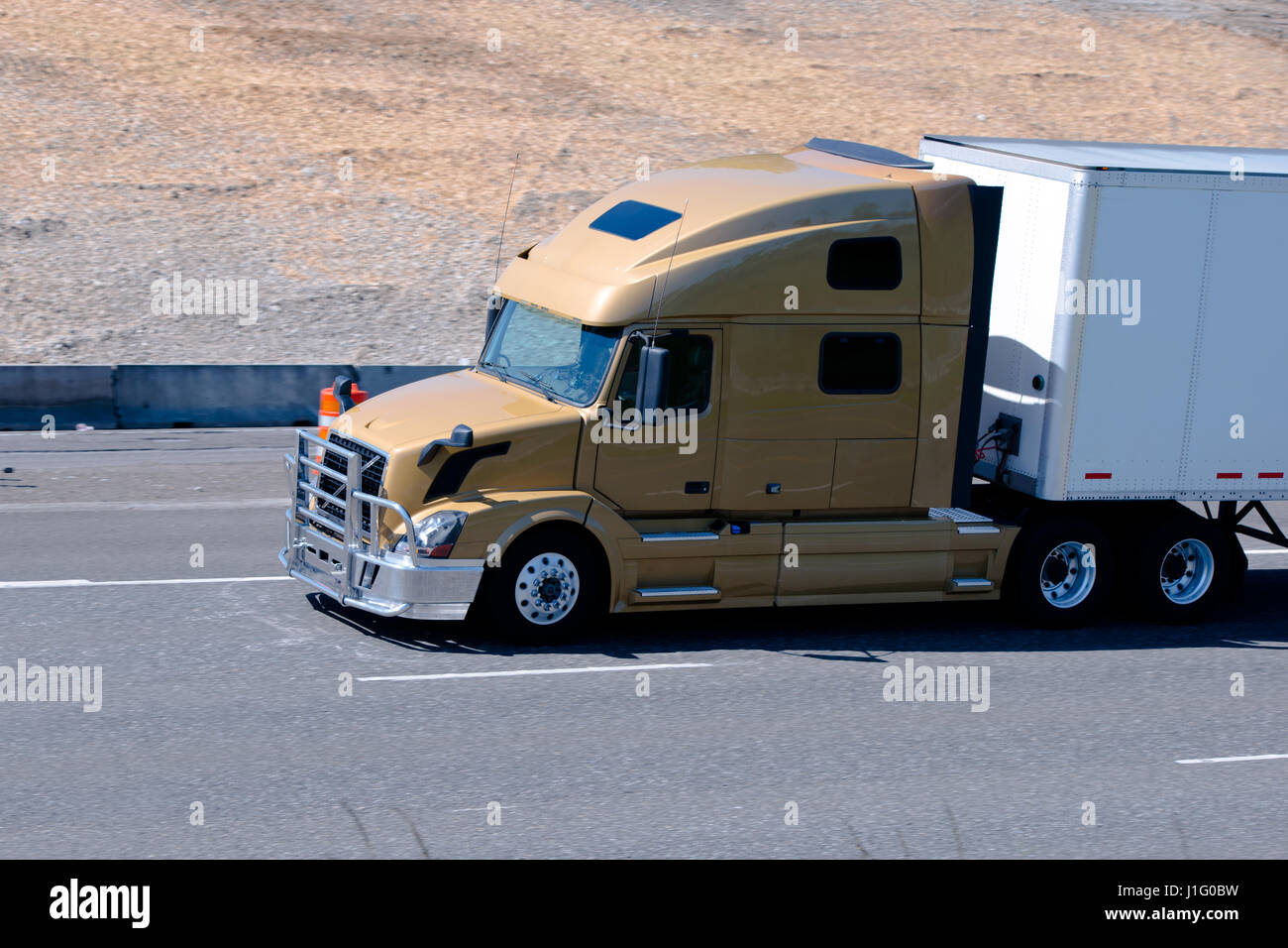 Moderno semi carrello design aerodinamico con confortevole cabina e una griglia di protezione dalla parte anteriore del carrello di colpi in marrone con dry van rimorchio Foto Stock