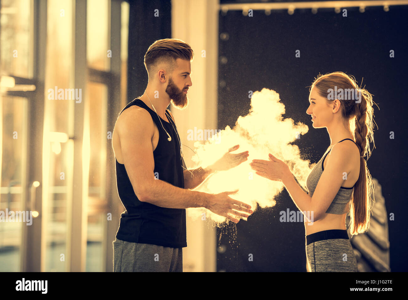 Giovane sportivo e sportive con polvere di gesso in piedi nel centro sportivo Foto Stock