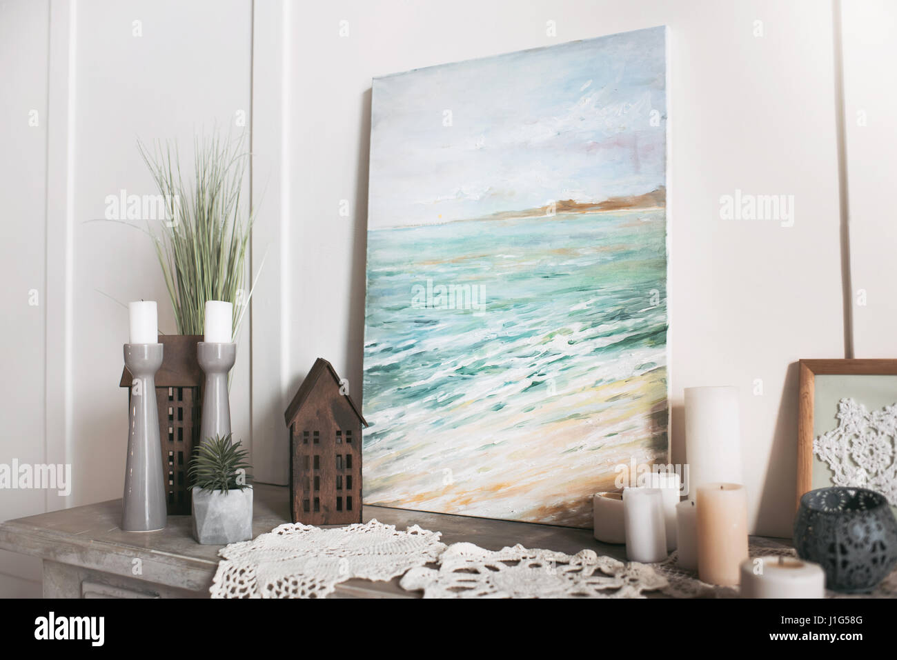 Foto di mare, candele e decorazioni in piedi sul ripiano a casa Foto Stock