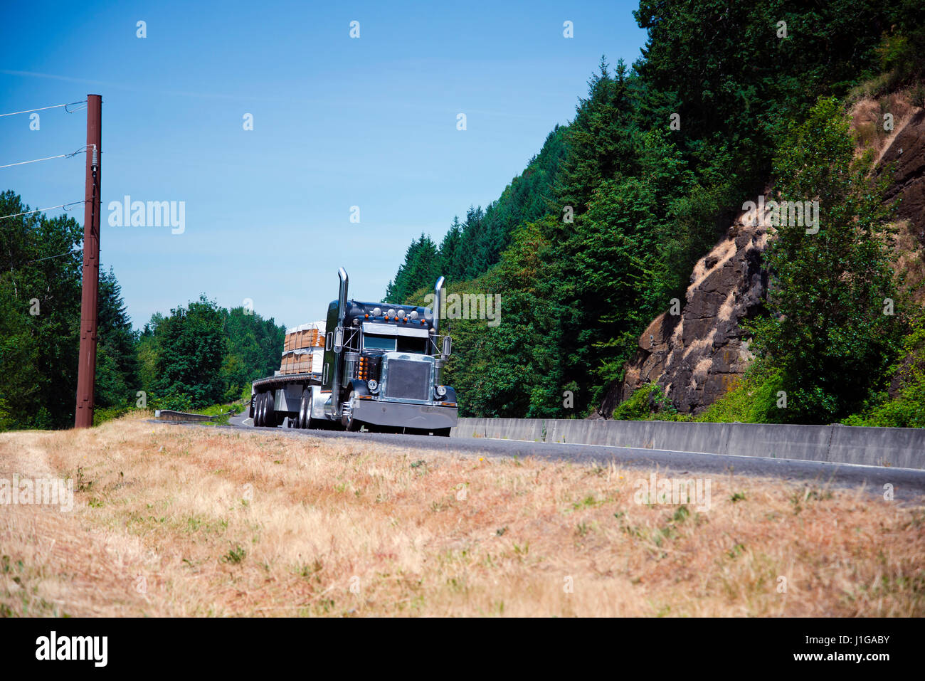 Potente spettacolare commerciale professionale classic blu scuro semi - camion con rimorchio aperto a letto piatto e accenti cromati trasporta i pannelli Foto Stock