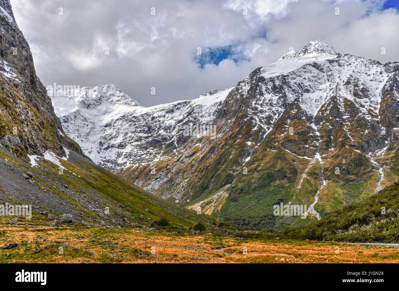 Montagne innevate in Milford Road, una delle più belle e panoramiche strade in Nuova Zelanda Foto Stock