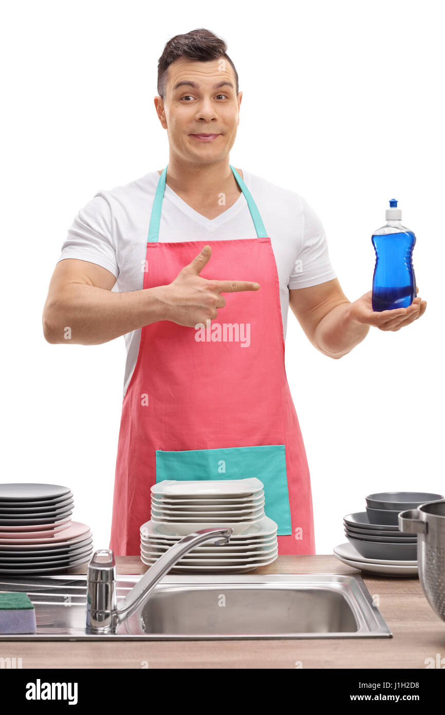 Giovane uomo dietro un lavandino tenendo un detergente e puntamento isolati su sfondo bianco Foto Stock