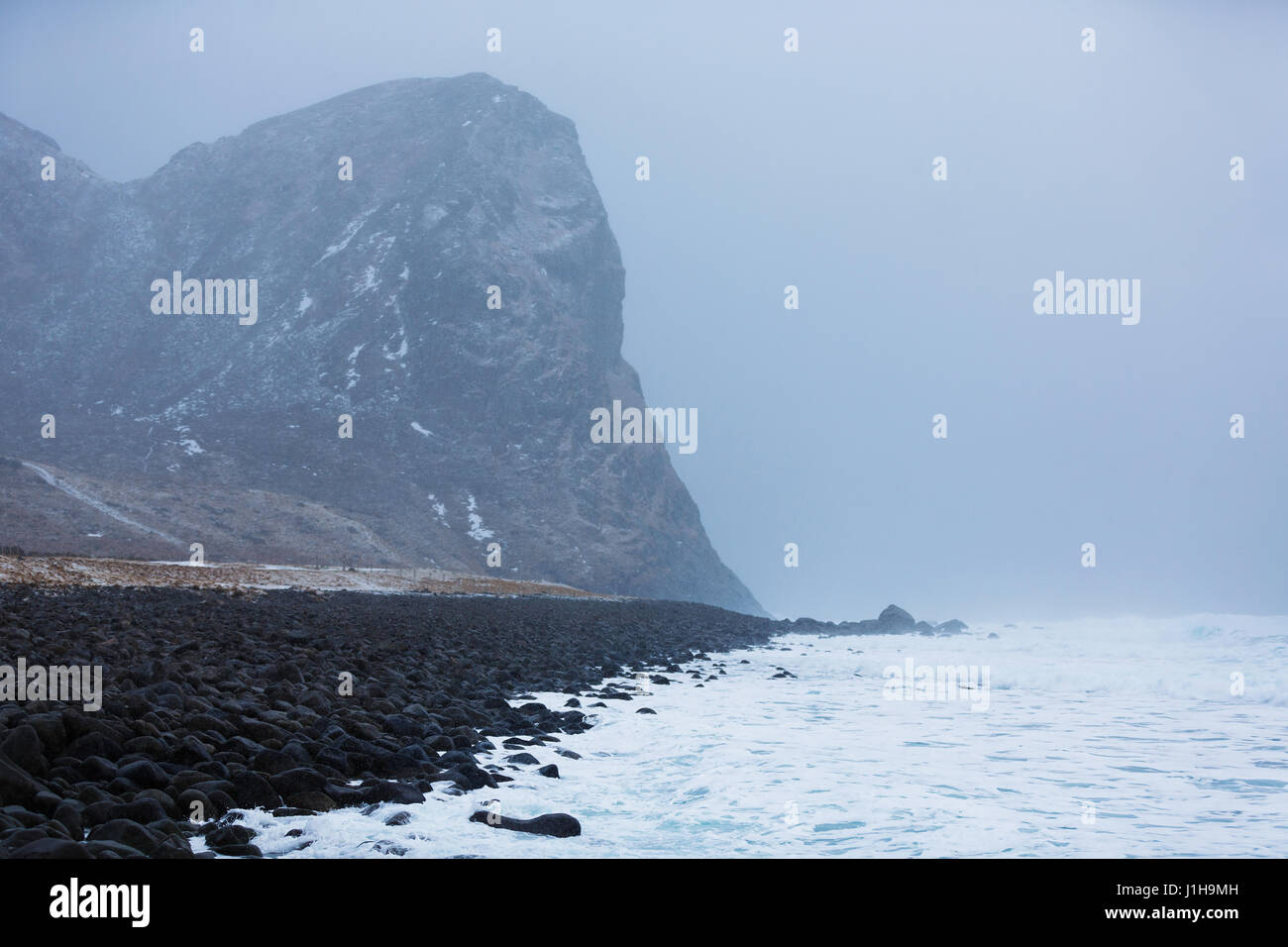 La sassosa costa durante il blizzard nelle Isole Lofoten Foto Stock