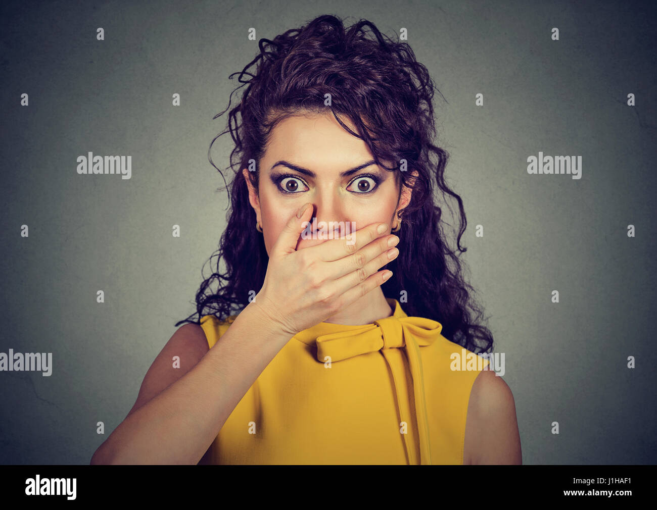 Interessato spaventata donna con la mano sulla bocca Foto Stock