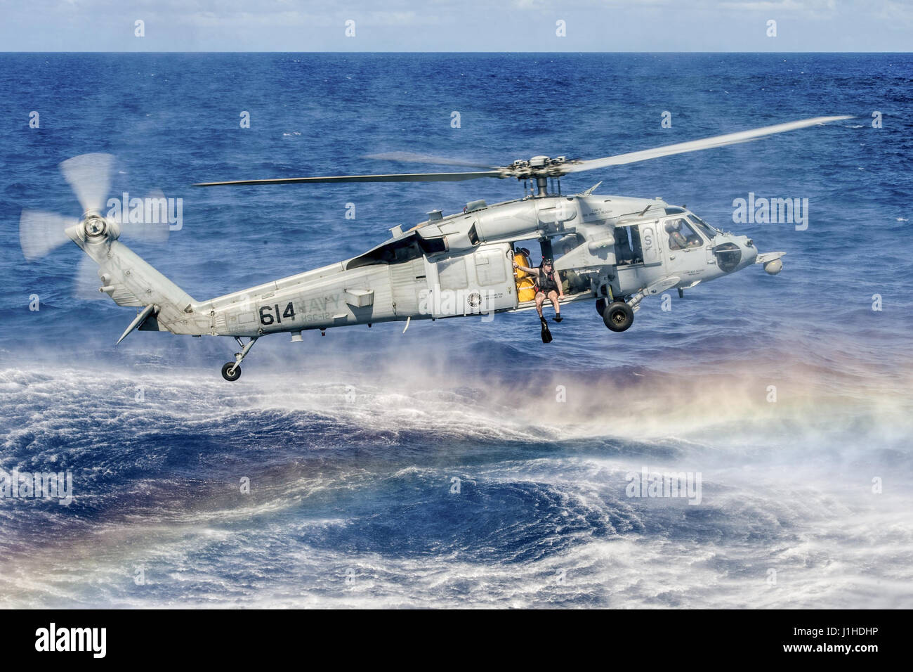 Ufficiale della marina si prepara a saltare da un MH-60S Seahawk durante la ricerca e il salvataggio della formazione Foto Stock