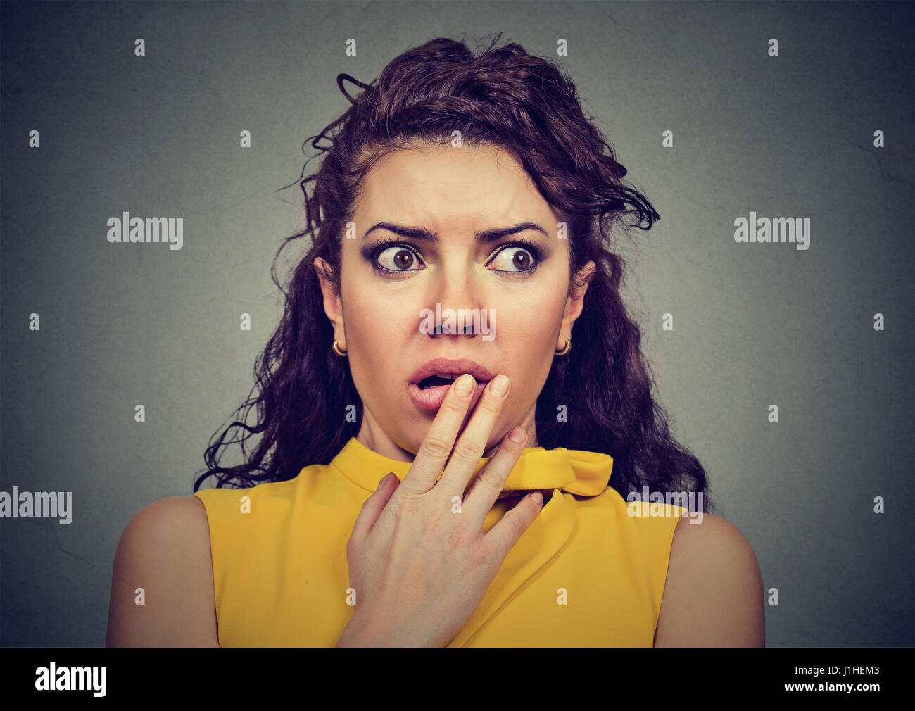 Spaventata scioccato donna isolato su sfondo grigio Foto Stock