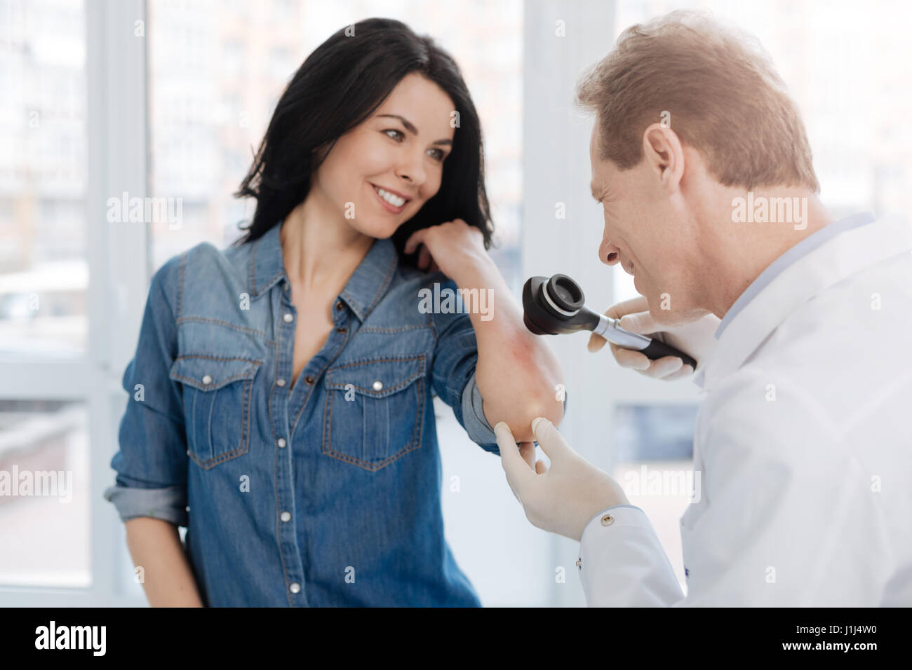 Sorridente dermatologo godendo di appuntamento con il paziente in ospedale Foto Stock