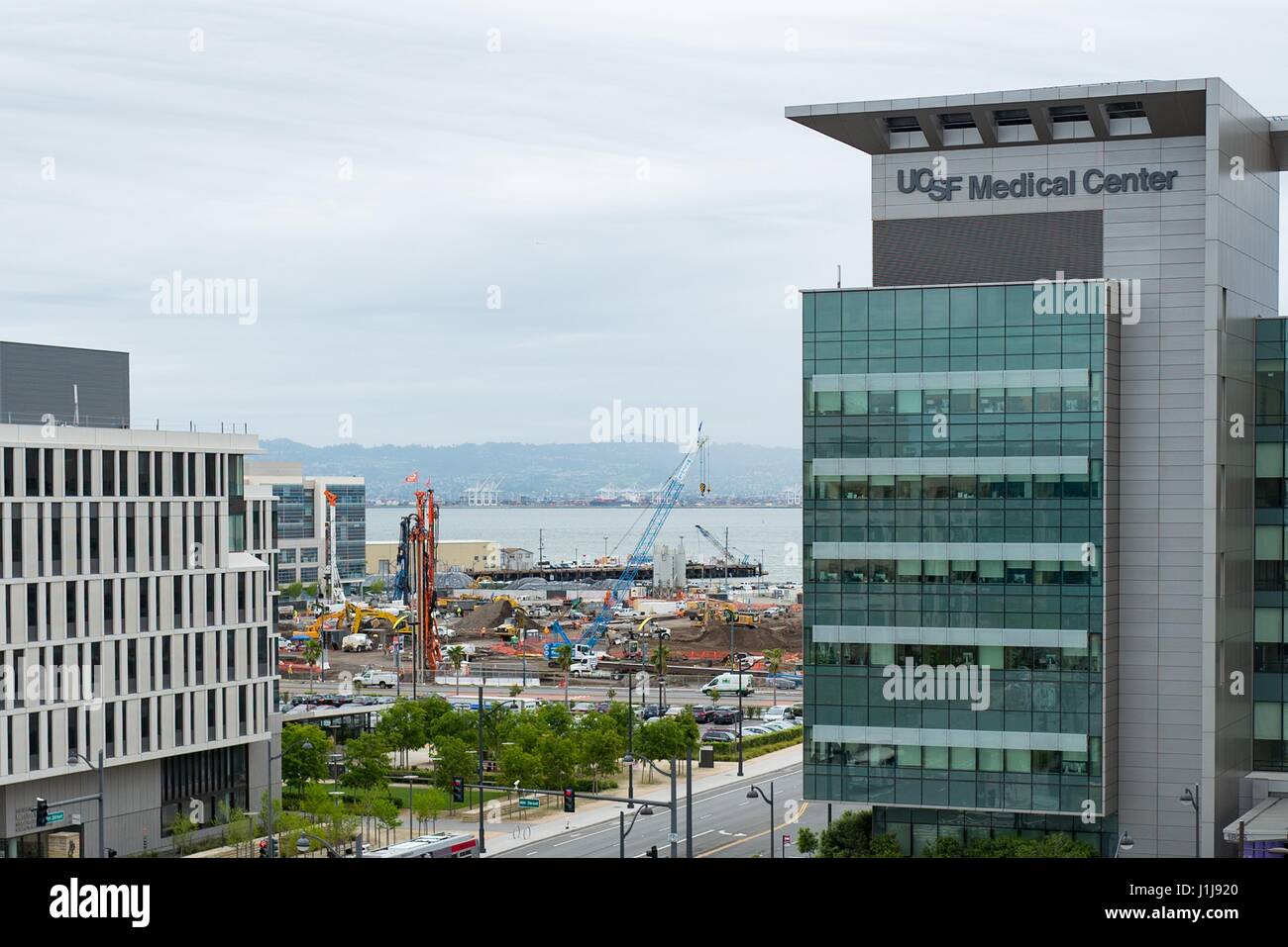 In questa vista aerea, gru edili sono visibili presso il sito del centro di Chase, il nuovo stadio per il Golden State Warriors squadra di basket, con la UCSF Medical Center visibile in primo piano, Mission Bay, San Francisco, California, 6 aprile 2017. Lo stadio della posizione è controversa, come ci sono preoccupazioni che aumenta il traffico stadium influirà negativamente UCSF nelle vicinanze dell'ospedale. Foto Stock