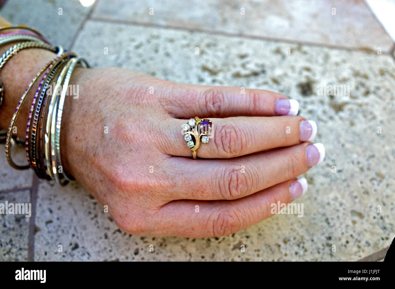 Donna che indossa Anello con diamanti e rubini, french manicure e bracciali. St Paul Minnesota MN USA Foto Stock