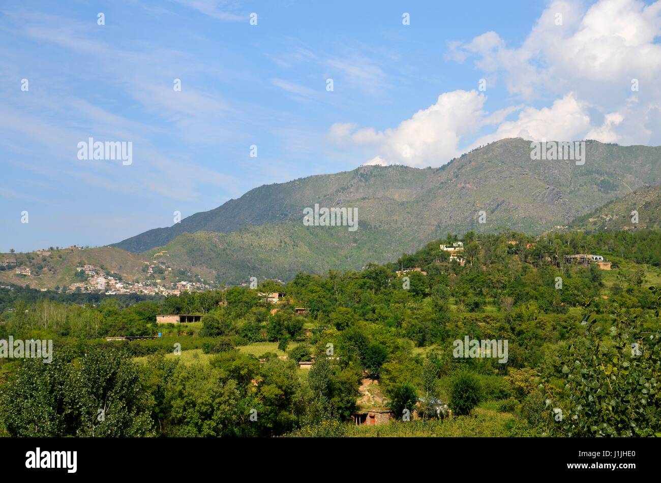 Le montagne del cielo e case nel villaggio rurale di verde della valle di Swat Khyber Pakhtoonkhwa Pakistan Foto Stock