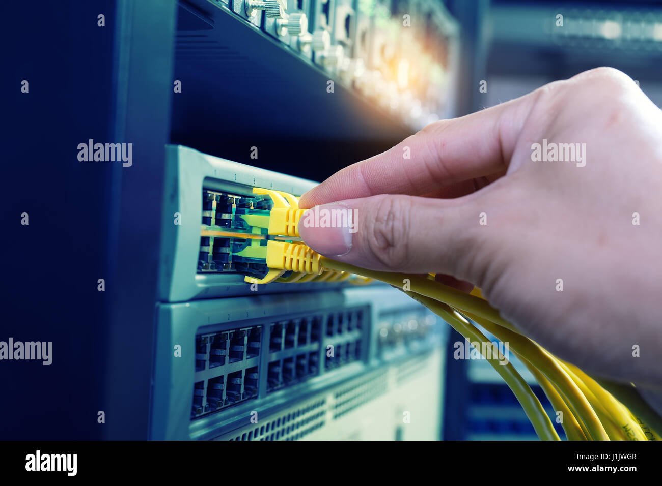 Mano di amministratore di rete di contenimento di cavi collegati ai server Foto Stock