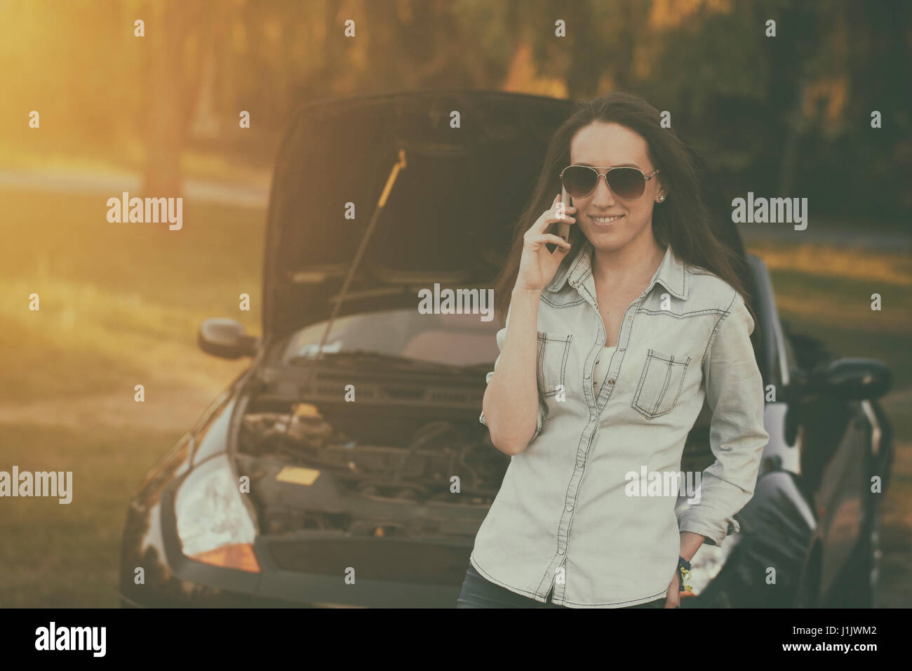 Donna con un ripartiti in auto in estate tramonto Foto Stock