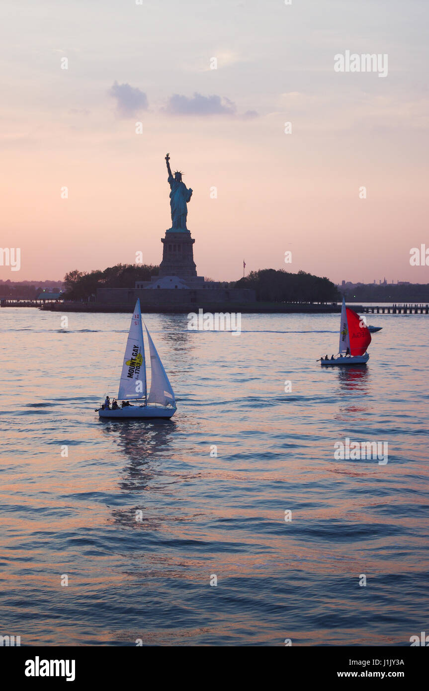 La statua della libertà nel tramonto, come pensione di yachts a vela nel porto di New York. Circoli Vela sono il modo migliore per godere la pensione. Foto Stock