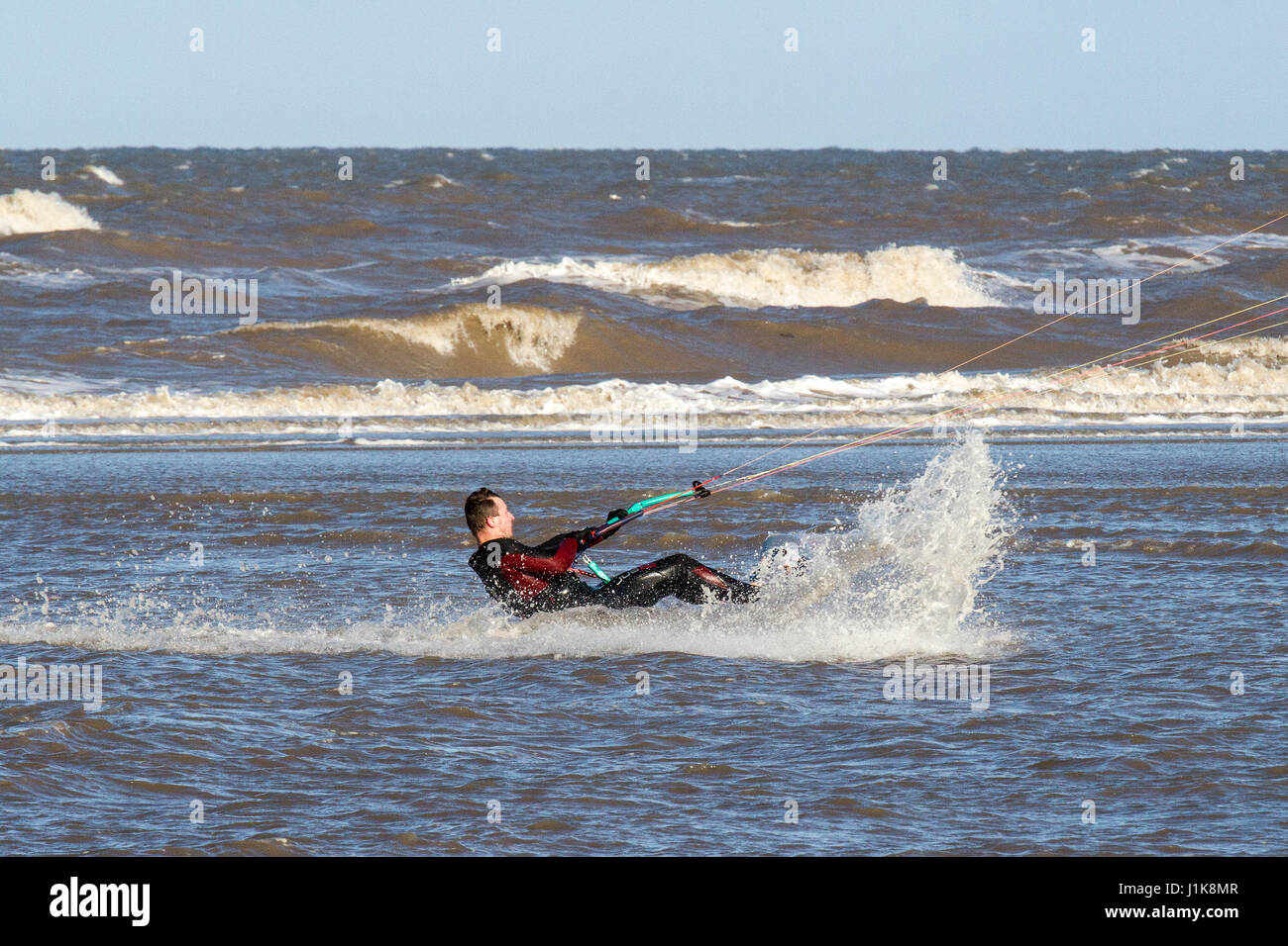 Ainsdale, Merseyside, 22 aprile 2017. Regno Unito Meteo. Un freddo vento del nord non interrompere questo coraggioso kite surfer da ottenere waist deep nel Mare d'Irlanda come egli rende la più soleggiata per iniziare la giornata sulla spiaggia Ainsdale nel Merseyside. Credito: Cernan Elias/Alamy Live News Foto Stock