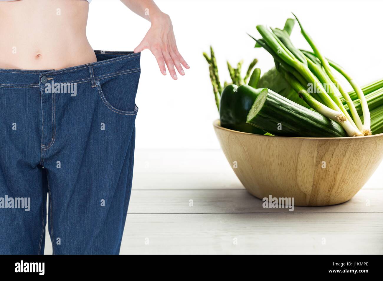 Composito Digitale della sezione mediana donna in jeans allentati da verdure Foto Stock