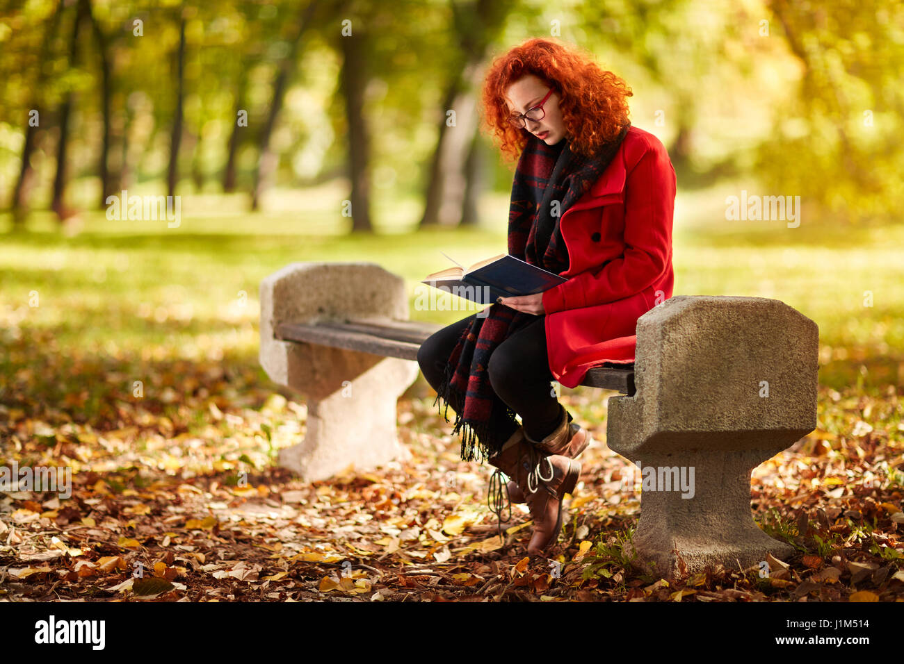 Redhead girl leggere il libro in natura nel mese di ottobre Foto Stock