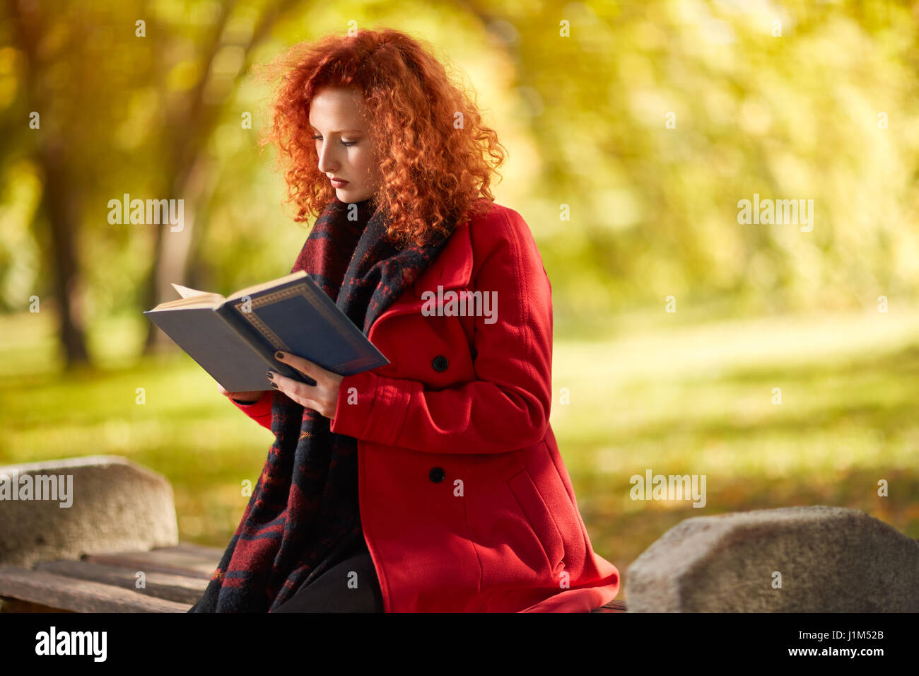 Capelli rossi femmina libro lettura in natura nel mese di ottobre Foto Stock