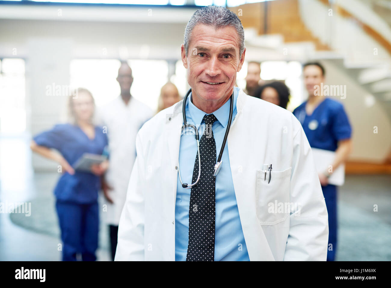 Adulto medico con lo stetoscopio in piedi in clinica e guardando la fotocamera. Foto Stock
