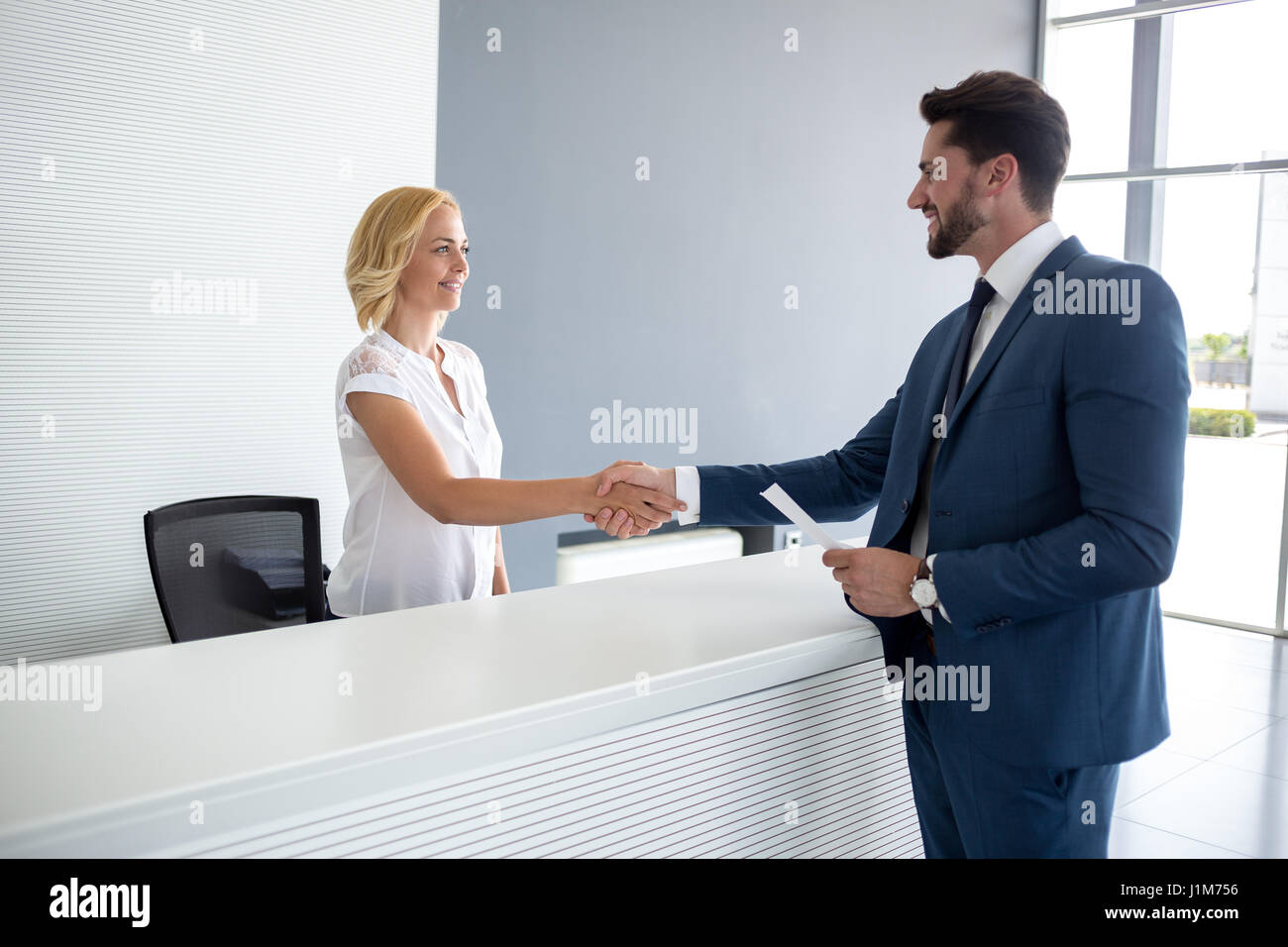 Bellissima femmina agitare le mani con il suo partner commerciale Foto Stock