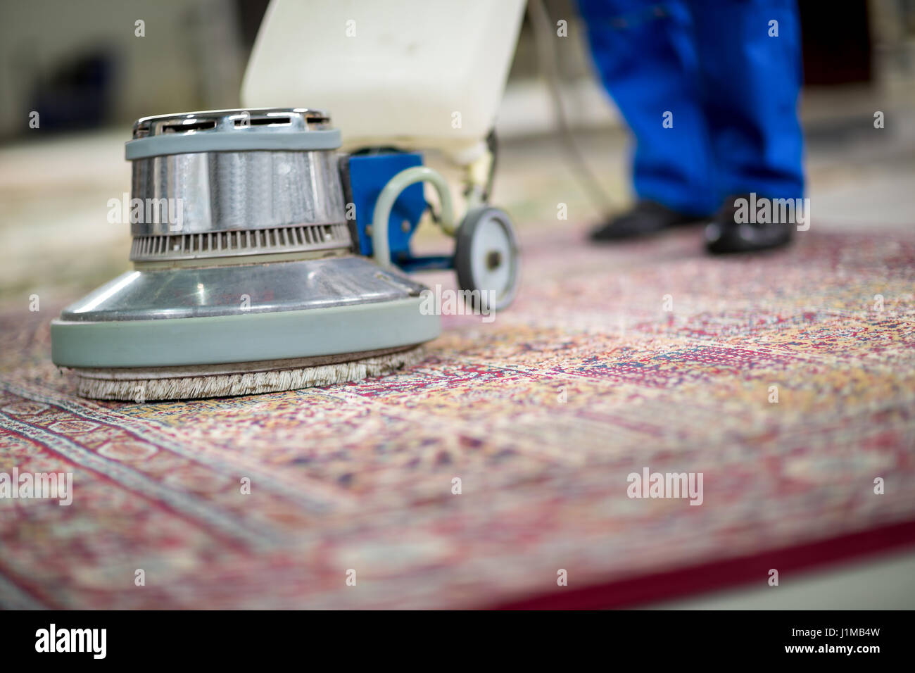 Il processo di pulizia dei tappeti con un aspirapolvere a vapore. Un  dipendente di un'azienda di pulizia pulisce il tappeto con il vapore Foto  stock - Alamy