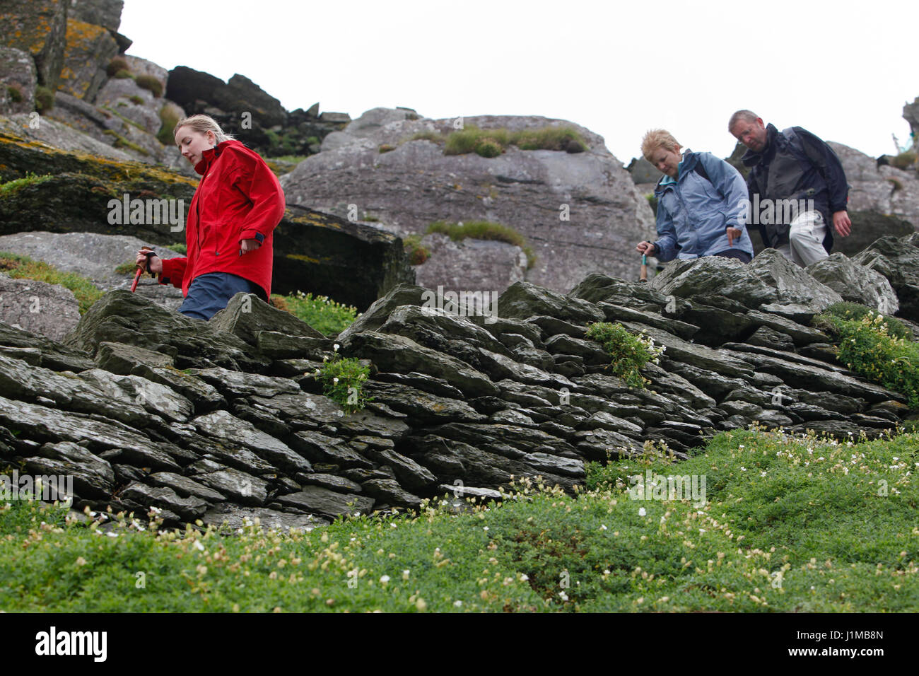 Un gruppo di persone a piedi il ripido sentiero lastricato su Skellig Michael, nella contea di Kerry. L'isola fu un monastero 1500 anni fa e ora è un'Unesco wor Foto Stock