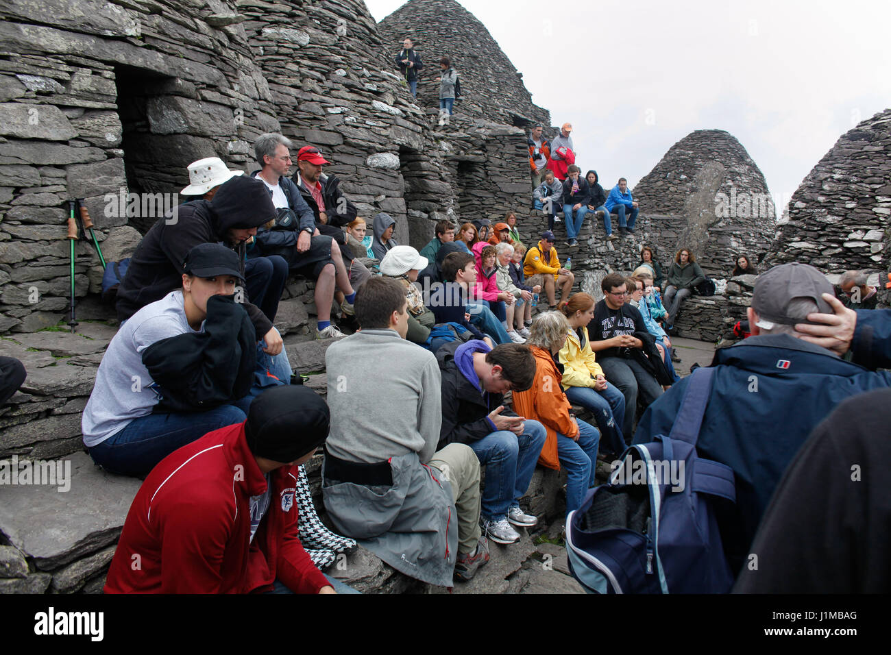 Un gruppo di visitatori di Skellig Michael ascoltare la guida parlare dell'isola monastero. Foto Stock