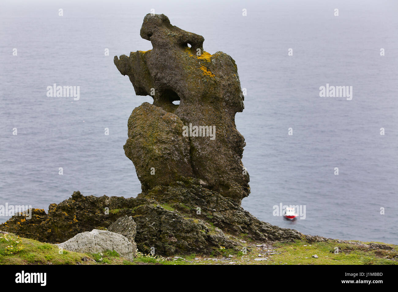 Un imponente struttura di roccia su Skellig Michael con un traghetto da Portmagee in background. Foto Stock