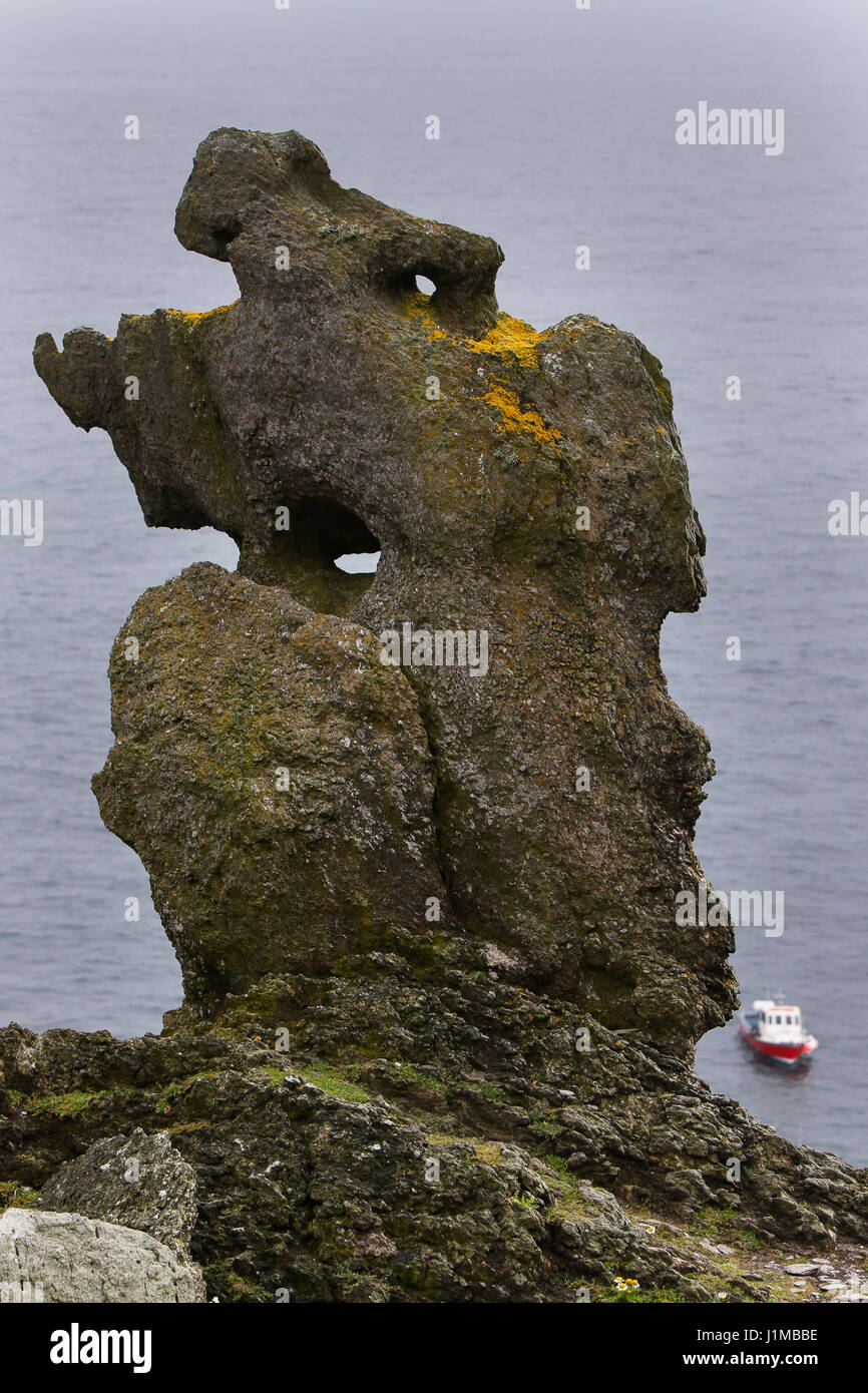 Un imponente struttura di roccia su Skellig Michael con un traghetto da Portmagee in background. Foto Stock
