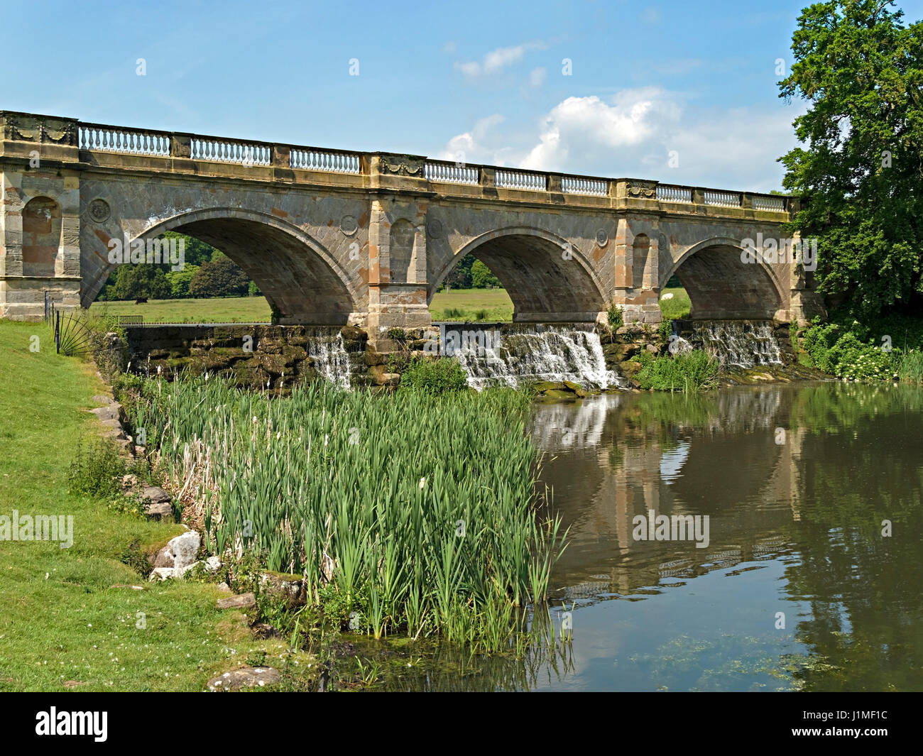 Il ponte di pietra con tre archi e Cascata Waterfall, Kedleston Bridge, Derbyshire, England, Regno Unito Foto Stock