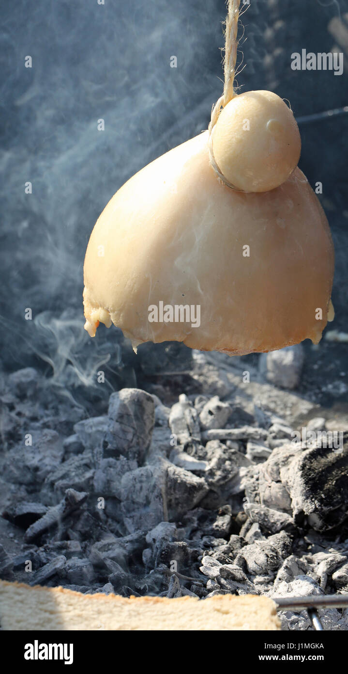 Formaggio fuso cotti e una fetta di pane tostato sulla sommità del tizzi caldi alfresco in stand italiano Foto Stock