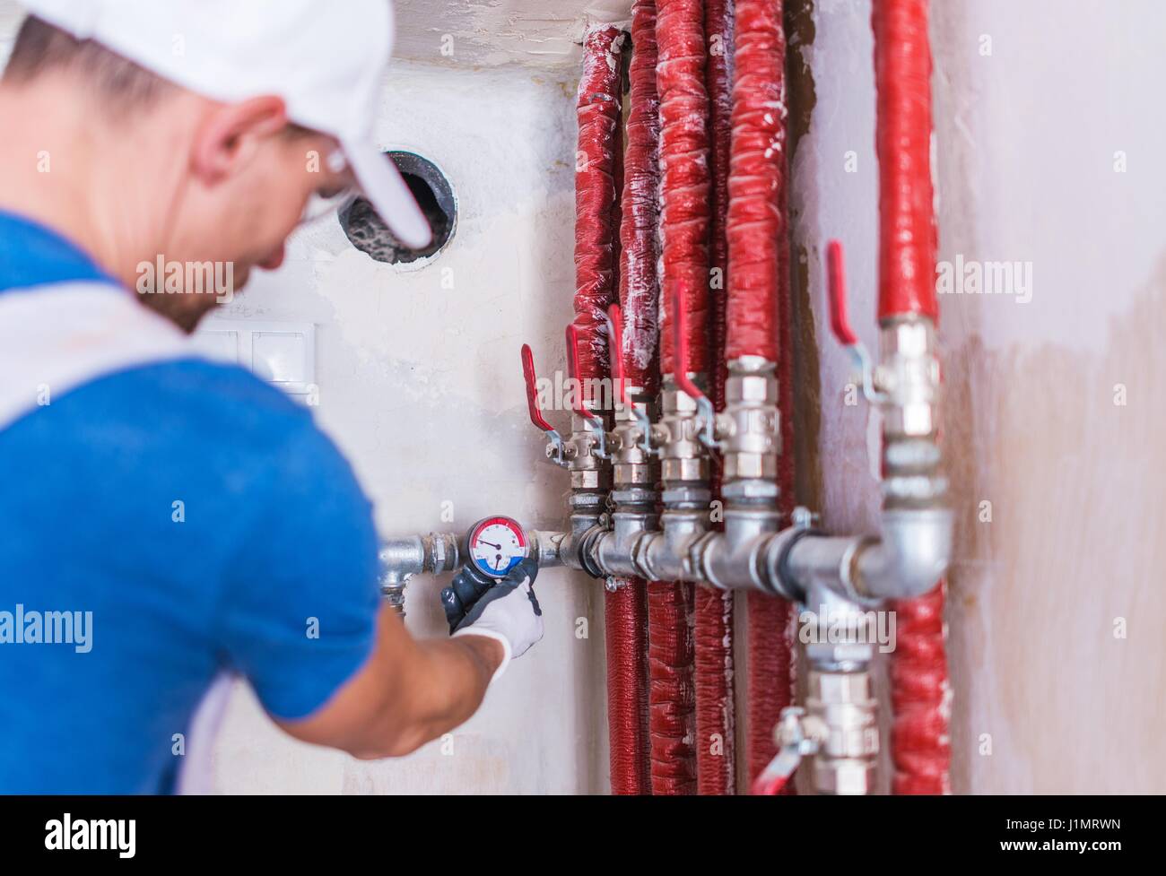 Plumber caucasica controllo sulle nuove zone residenziali sistema di approvvigionamento di acqua. Foto Stock
