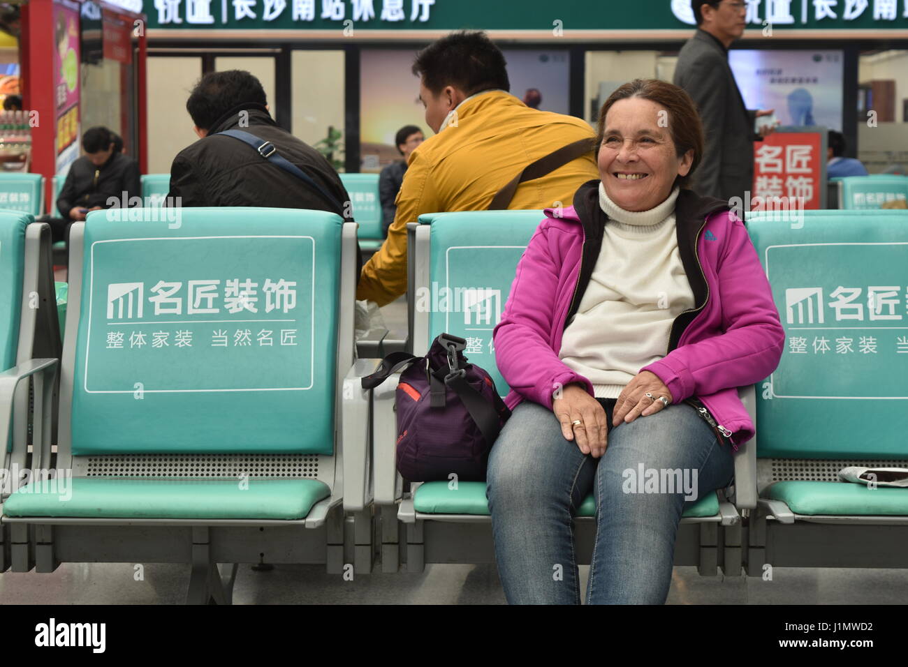 Eccitato senior sorridente turista femminile in Cina stazione ferroviaria per treni ad alta velocità area di attesa, Changsha, nella provincia del Hunan, Foto Stock