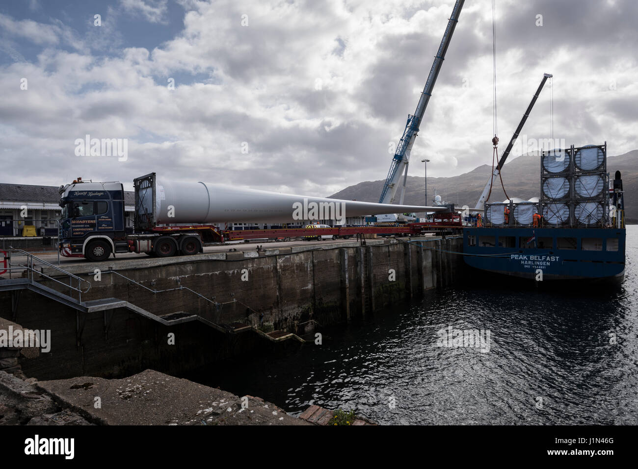 Grandi turbine eoliche le pale del rotore essendo sbarcato da una nave a Kyle of Lochalsh Harbour su un rimorchio telescopico per il proseguimento del trasporto su strada. Foto Stock