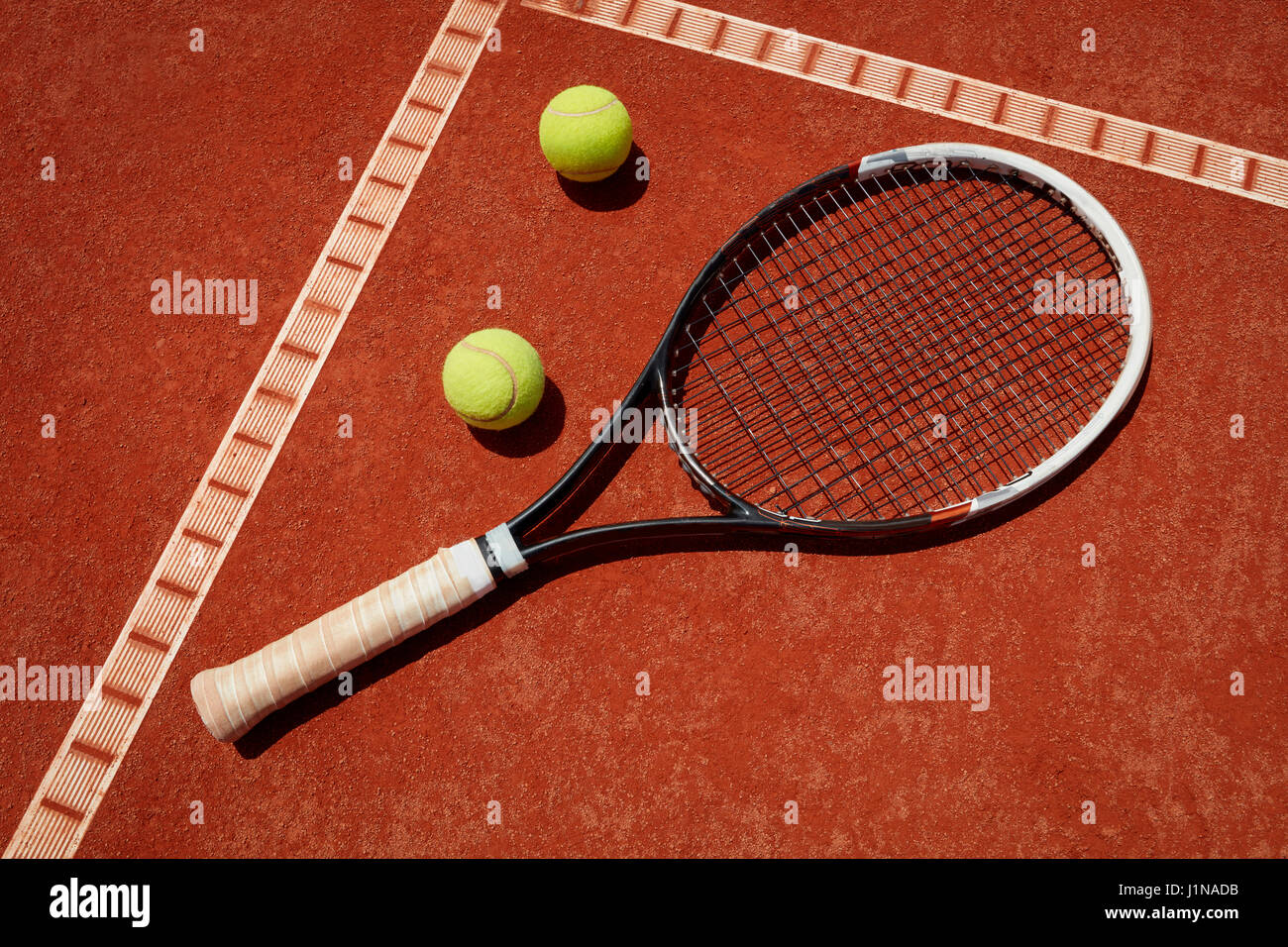 Close up di racchette e palline da tennis sul terreno a red scorie Foto Stock