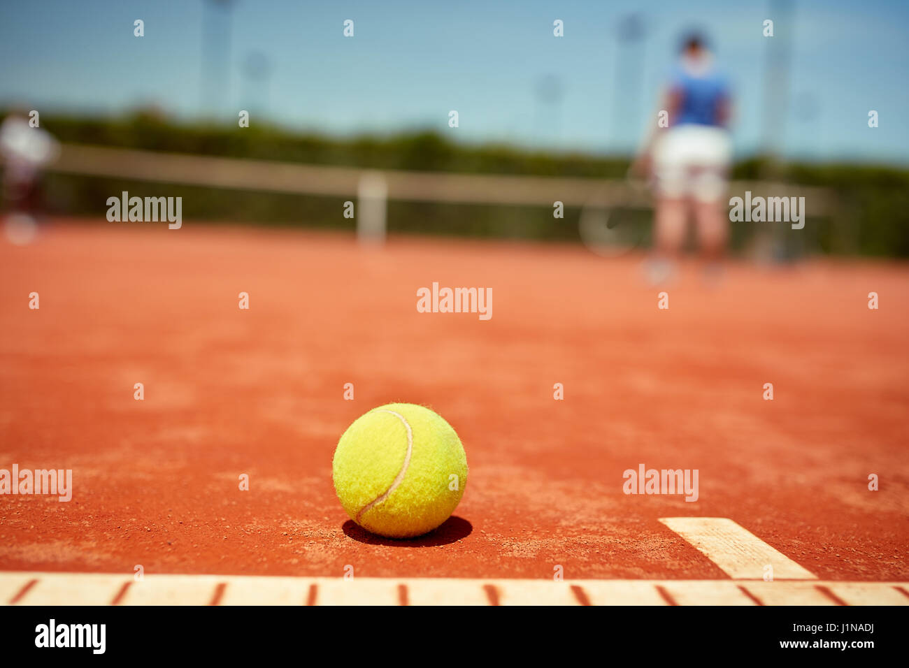 Close up di giallo palla da tennis su terra rossa Foto Stock