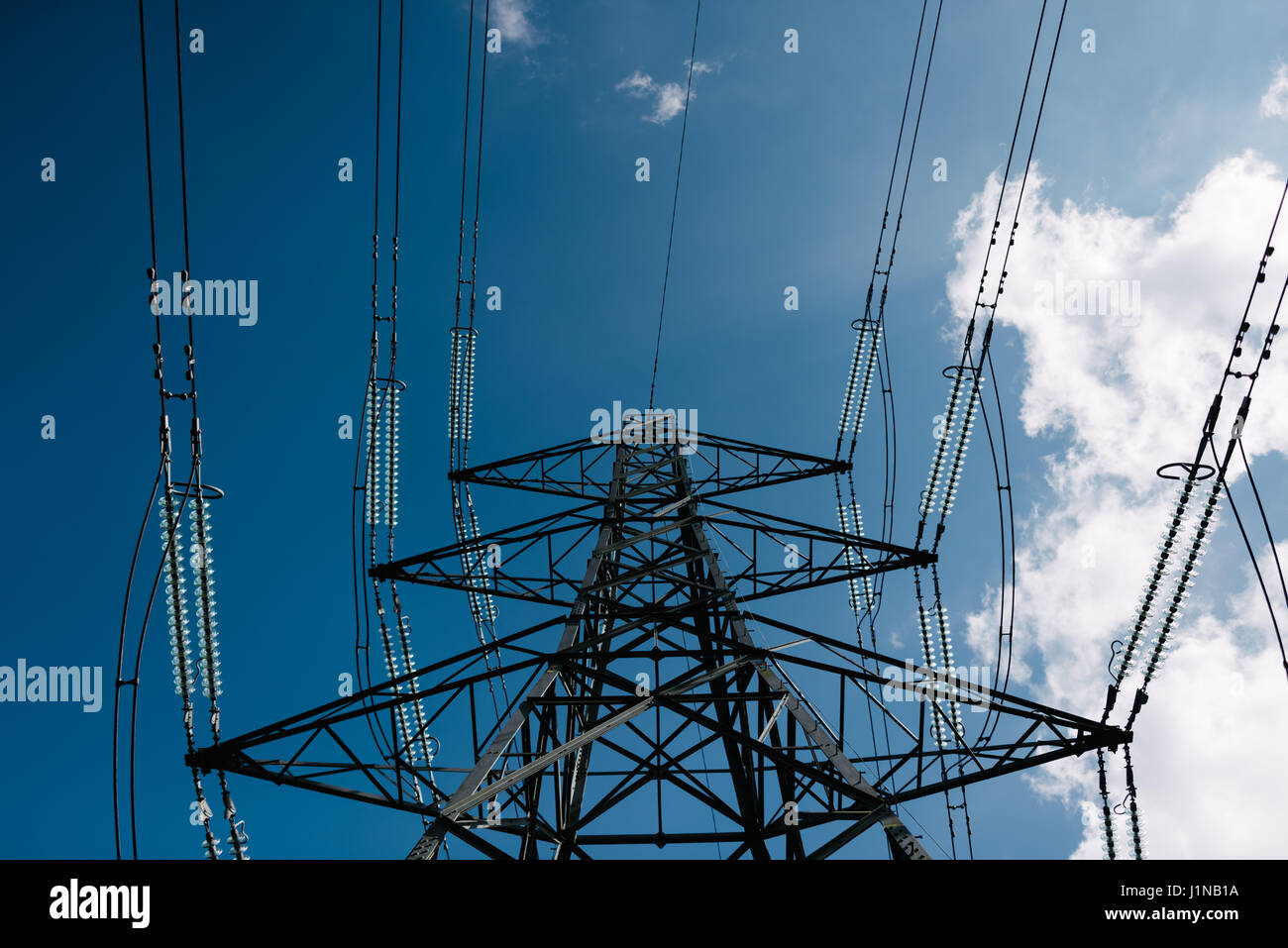 Tralicci di energia elettrica su un cielo blu sullo sfondo Foto Stock