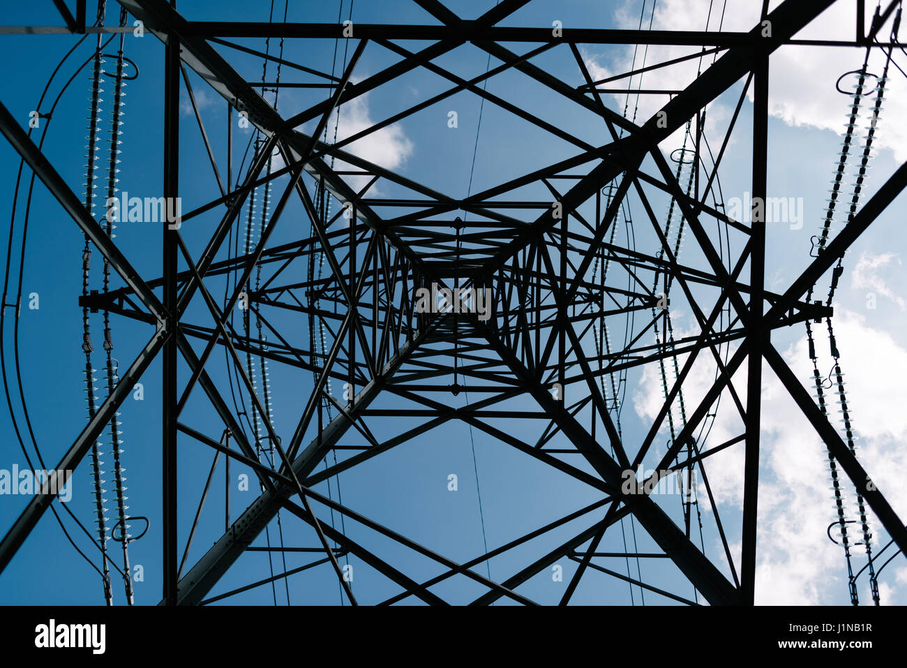 Tralicci di energia elettrica su un cielo blu sullo sfondo Foto Stock