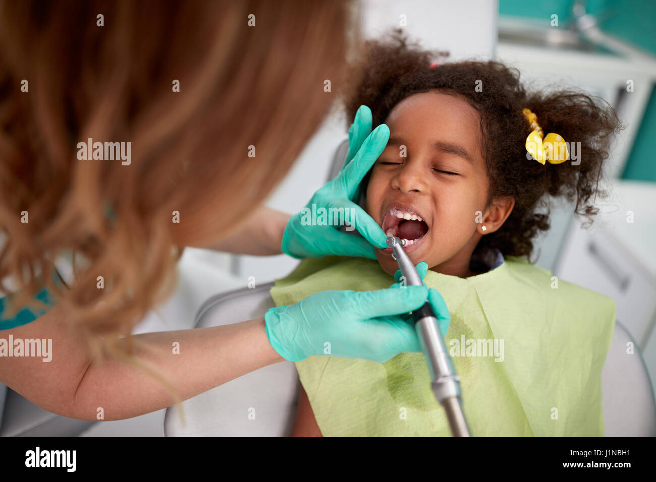 Bella femmina pazientemente dentista denti polacco per bambini in pratica dentistica Foto Stock