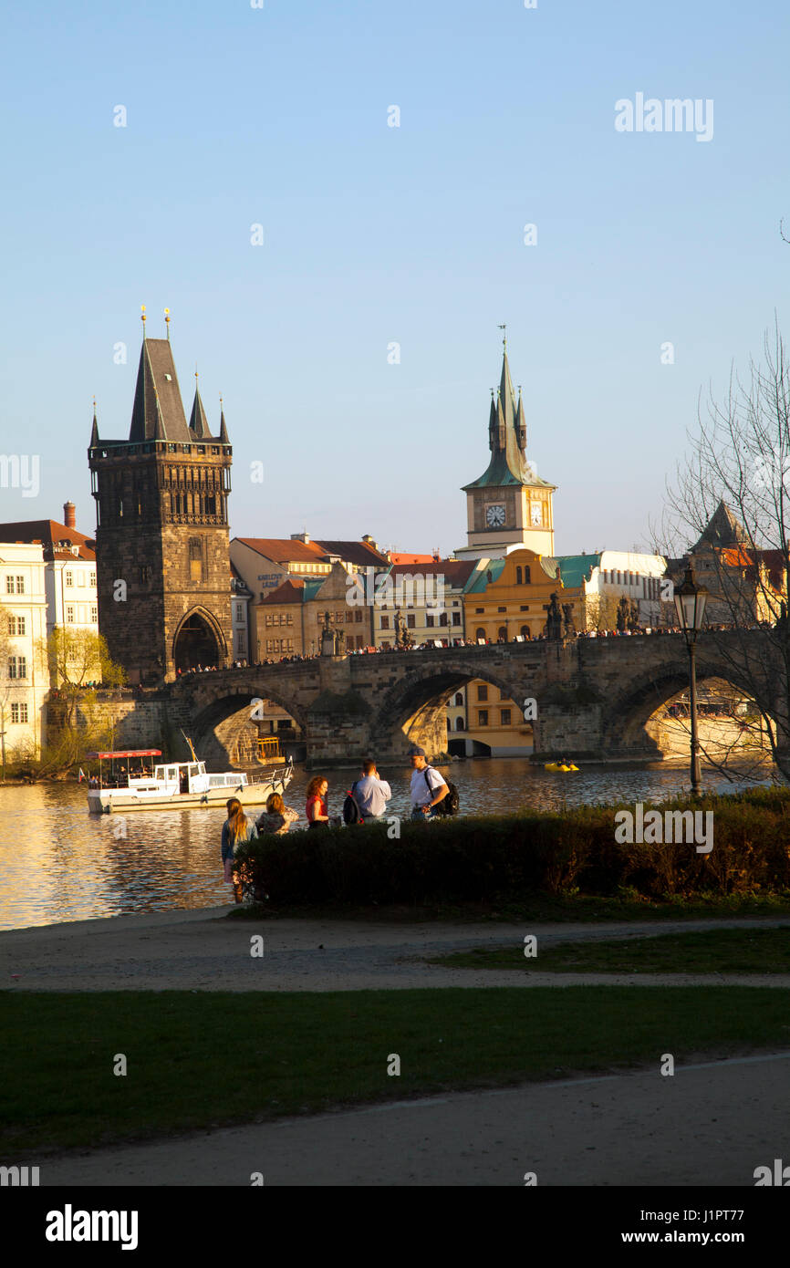 Vista sul fiume Moldava a Praga, guardando verso il Ponte Carlo e la città vecchia, con turisti e villeggianti godendo la vista. Foto Stock