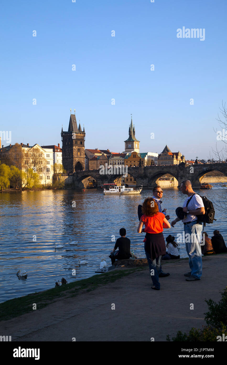 Vista sul fiume Moldava a Praga, guardando verso il Ponte Carlo e la città vecchia, con turisti e villeggianti godendo la vista. Foto Stock