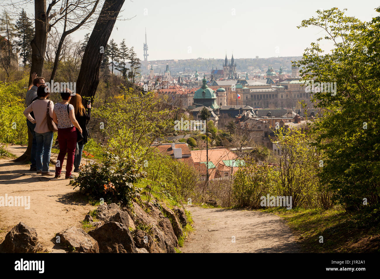 Gruppo di turisti tenendo in vista di Praga da un punto di vista in un parco sopra la città Foto Stock