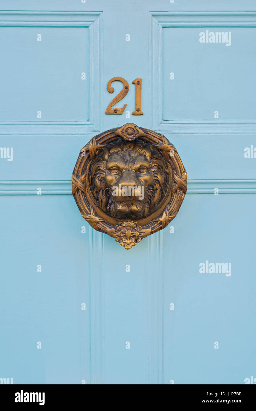 Ottone Lions Head porta respingente e 21 numero di casa su un blu porta in legno. Warwick Warwickshire, Inghilterra Foto Stock