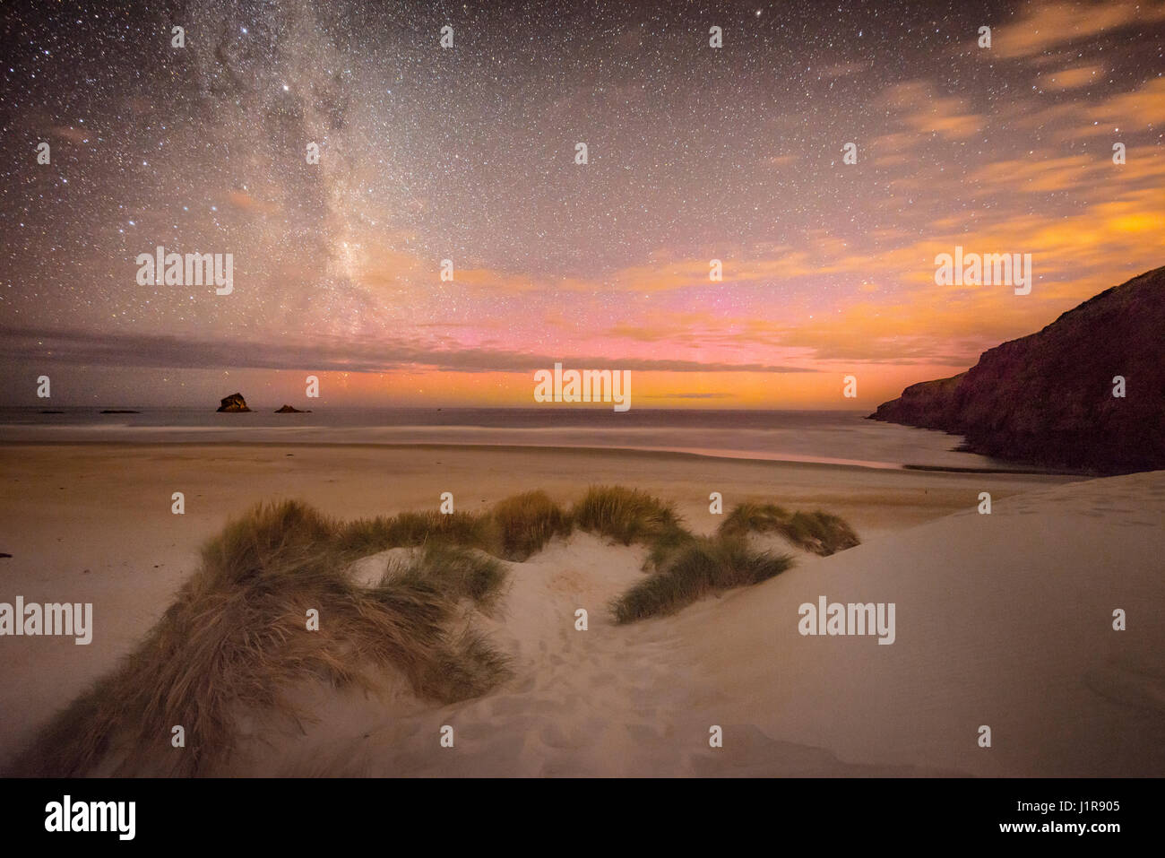 Le luci del sud, aurora australis con Via Lattea sopra il mare, dune di sabbia, Sandfly Bay, a Dunedin, Otago, Penisola di Otago Foto Stock