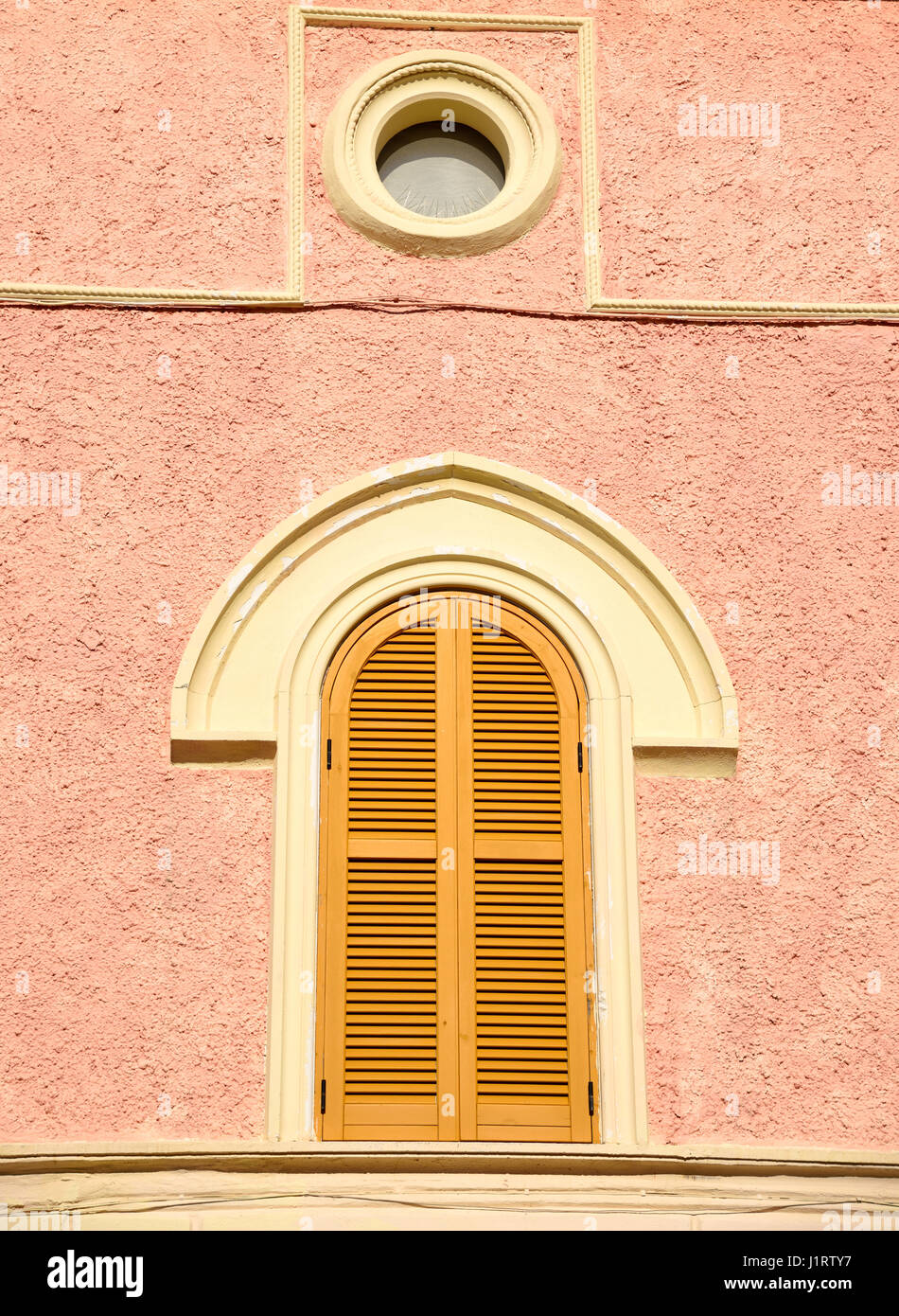 Finestra con arco sulla parete rosa Foto Stock