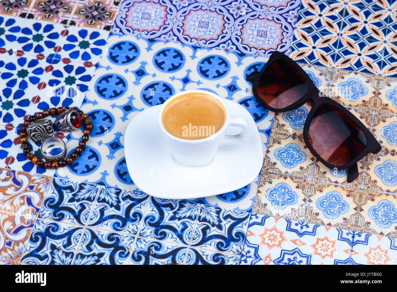Tazza di caffè arabico su un Orientale sfondo colorato / tazza di espresso su una orientale colorato con fiori, anelli e Tamr date Foto Stock